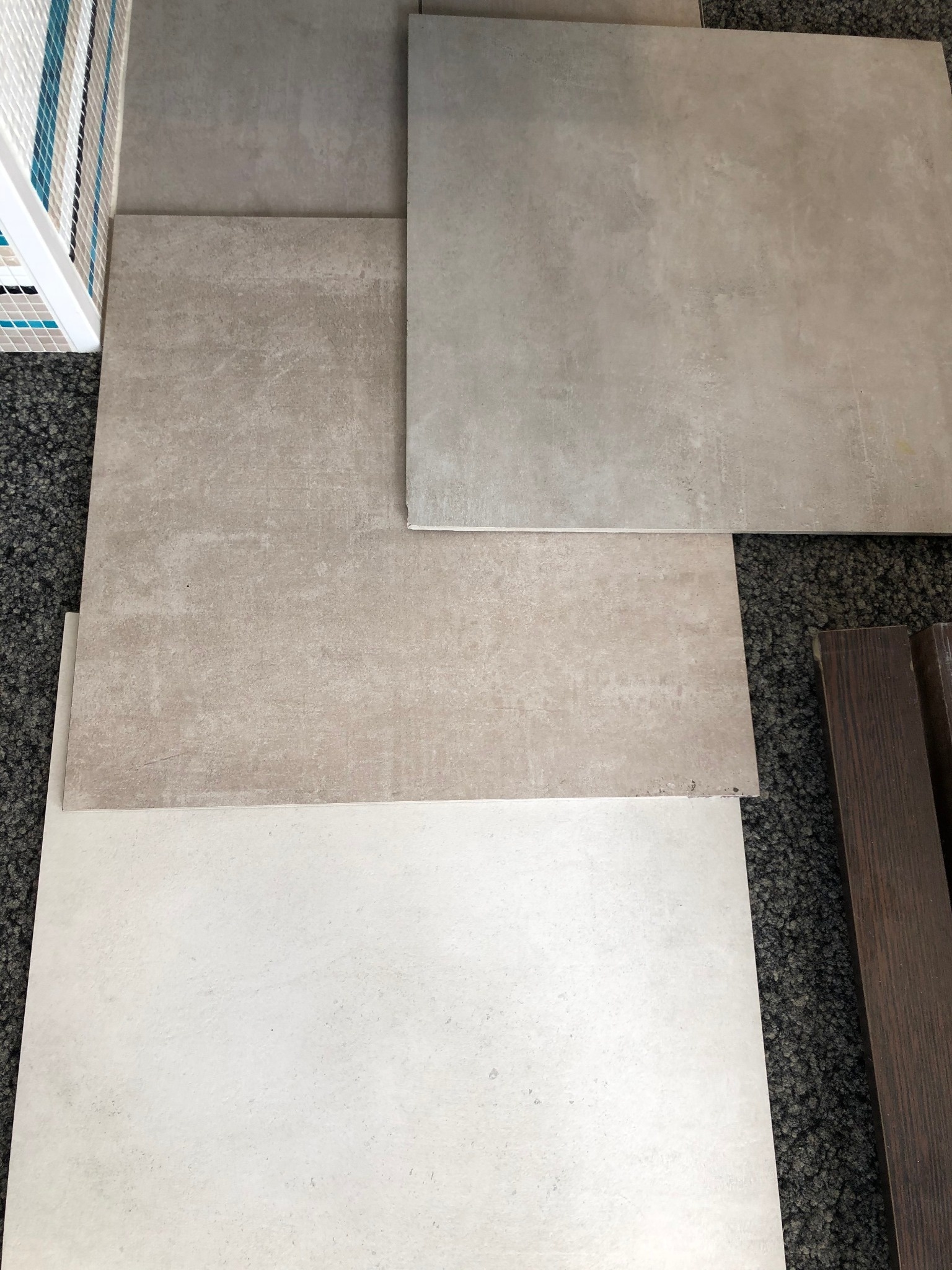 Großformatige Bodenfliesen in mehreren Beige- und Grautönen, um 90 Grad im Uhrzeigersinn gedreht
