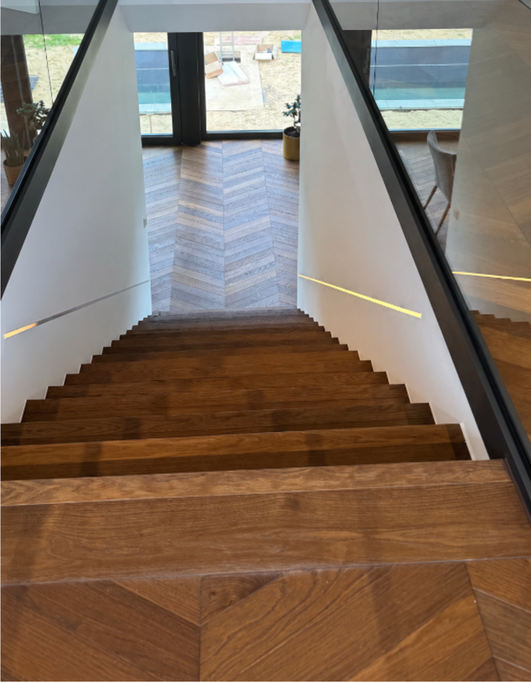 Treppenraum mit Glasgeländern und integrierten Lichtbändern